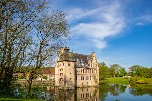 Dortmund, Germany - Apr 12, 2019: Far view on ancient castle on water Bodelschwingh in Dortmund, Germany