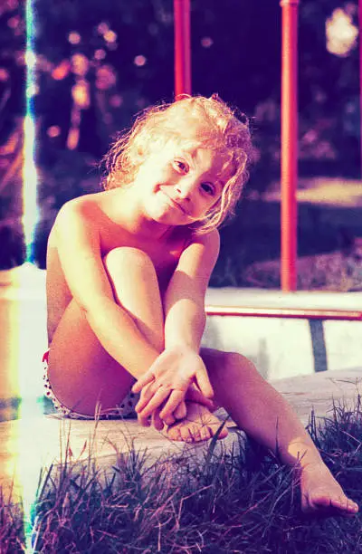 Vintage photo of a cute blonde girl on summer vacations