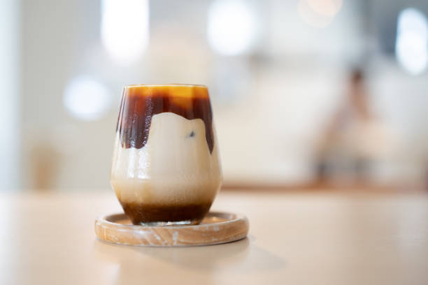 Ice cold caramel latte on wooden table in cafe