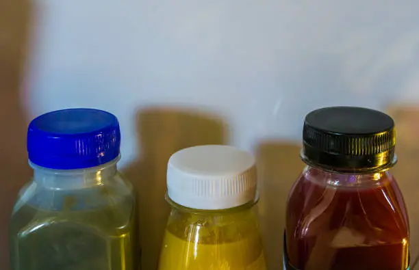 Photo of three bottles of fruit and vegetable smoothies in a refrigerator, popular and healthy products
