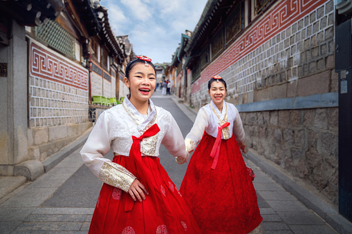 Korean lady in Hanbok or Korea dress and walk in an ancient town and Gyeongbokgung Palace in seoul, Seoul city, South Korea.