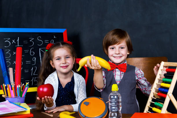 istock Schoolgirl and schoolboy in classroom at elementary school 1161734990
