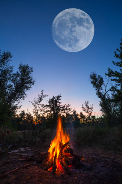istock huge moon on the night sky above the camp fire 1161736440