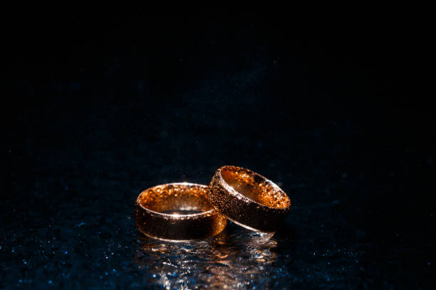istock Beautiful wedding gold rings on dark background 1161739840