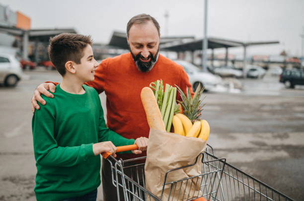 istock Father and son pushing cart together 1161744909
