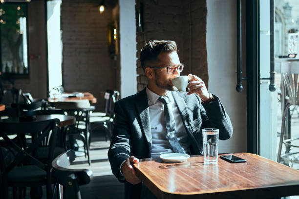 istock Happy businessman on a coffee break looking through window 1161746418
