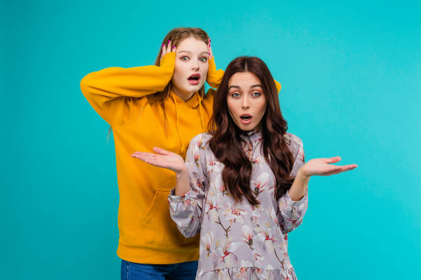 istock 2 young women isolated over turquoise background 1161749364