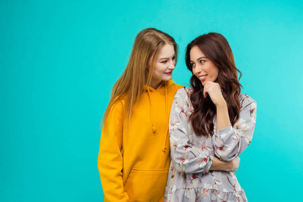 istock 2 young women isolated over turquoise background 1161750129