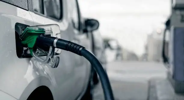 Pumping gasoline fuel in car.
