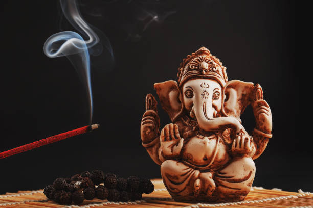 Hindu God Ganesh On A Black Background Rudraksha Statue And Rosary On A  Wooden Table With A Red Incense Stick And Incense Smoke Stock Photo -  Download Image Now - iStock
