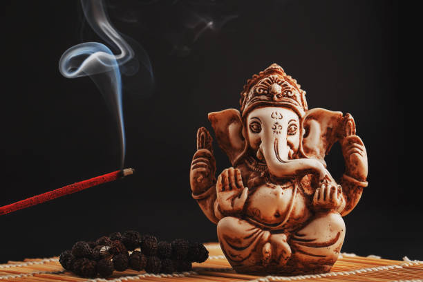 Hindu God Ganesh On A Black Background Rudraksha Statue And Rosary On A Wooden Table With A Red Incense Stick And Incense Smoke Stock Photo - Download Image Now - iStock Hindu God Ganesh On A Black Background Rudraksha Statue And Rosary On A Wooden Table With A Red Incense Stick And Incense Smoke Stock Photo - Download Image Now - iStock