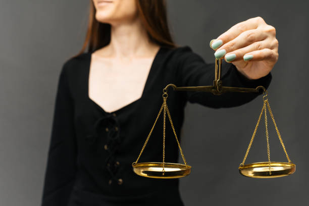 istock Serious woman holding the justice scale on dark background 1161754619