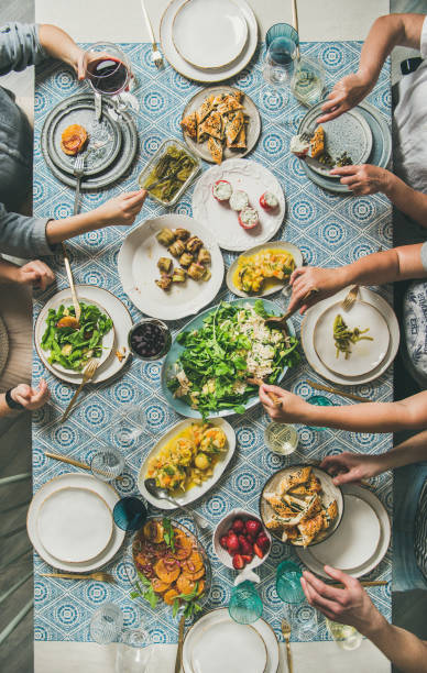 istock Mediterranean style dinner and human hands holding drinks and food 1161758107