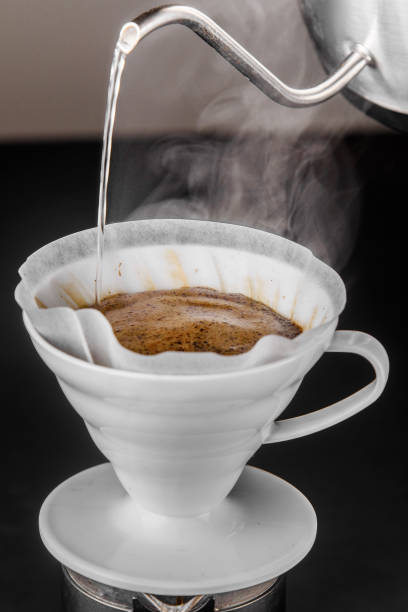 istock Alternative method of making coffee. coffeemaker is a manual pour-over style glass. Cofee brewing on black background 1161758122