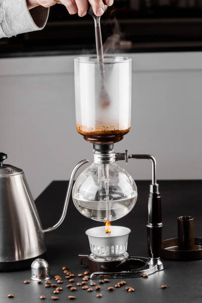 istock Siphon alternative method of making coffee. coffeemaker is a manual pour-over style glass. Cofee brewing on black background 1161758145