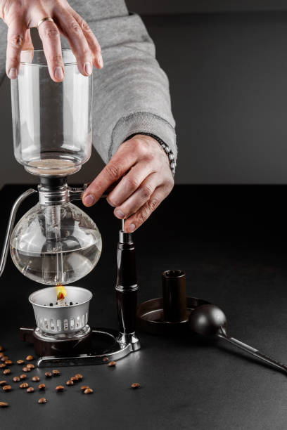 istock Siphon alternative method of making coffee. coffeemaker is a manual pour-over style glass. Cofee brewing on black background 1161758147