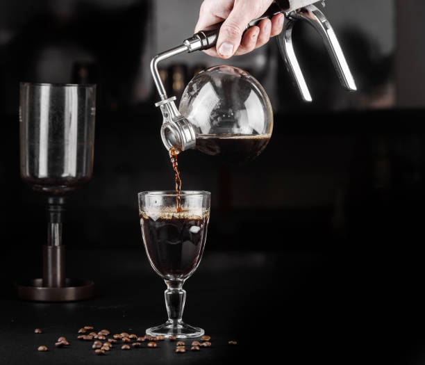 istock Alternative method of making coffee. coffeemaker is a manual pour-over style glass. Cofee brewing on black background 1161758163