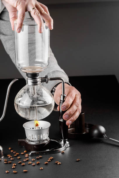 istock Siphon alternative method of making coffee. coffeemaker is a manual pour-over style glass. Cofee brewing on black background 1161758187