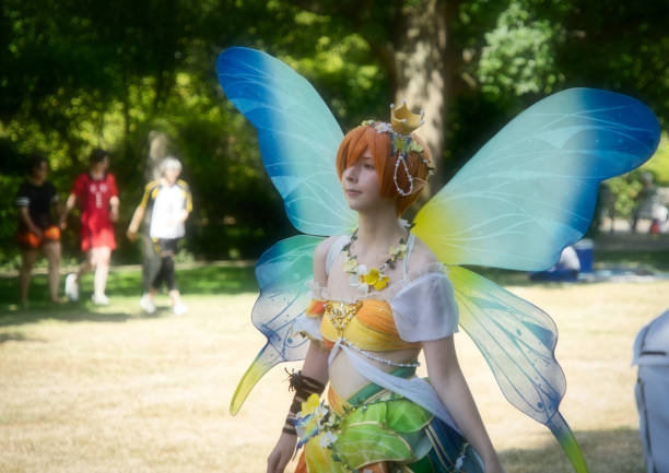 yong mujer cosplayer posa durante el festival germano-japonés en el parque público, personaje manga de una mariposa con alas azules - princesa de anime fotografías e imágenes de stock