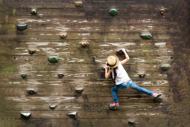 壁を登る女の子 - 克服 ストックフォトと画像