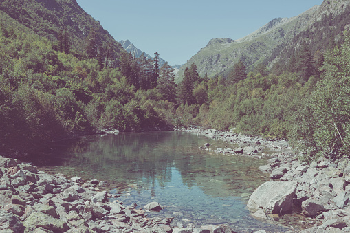 Closeup view of lake scenes in mountains, national park Dombay, Caucasus, Russia, Europe. Sunshine weather, blue color sky, far away green trees. Colorful summer day, time