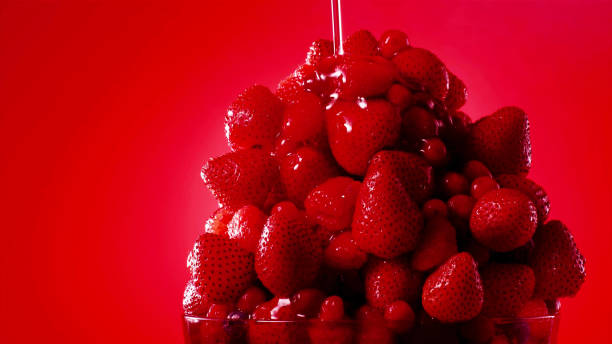 A mountain of strawberries is watered with sweet syrup