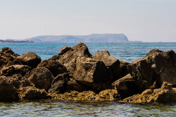 Rocks standing out from the sea and Island Of Dia in distance, Malia, Crete, Greece