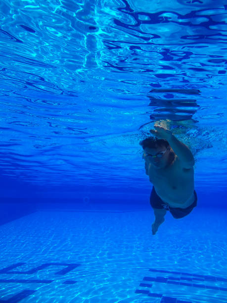 istock Young man swimming the front crawl in a pool, taken underwater 1161781403