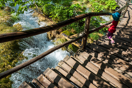 3 year old girl watching the water rushing down some rocks.
Official photography permission obtained by the Plitvice Lakes National Park and available on request.