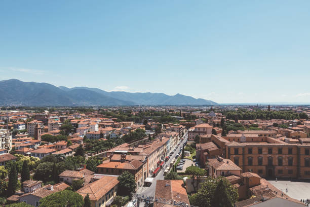 Panoramic view of Pisa city with historic buildings and far away mountains Panoramic view of Pisa city with historic buildings and far away mountains from Tower of Pisa. Summer day and sunny blue sky pisa leaning tower of pisa tower famous place stock pictures, royalty-free photos & images