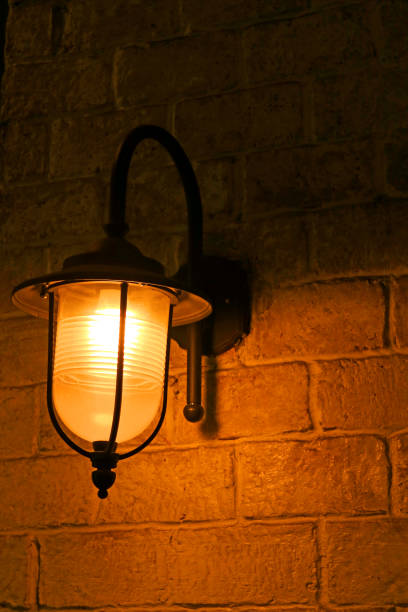 istock Vertical image of retro style lamp on the old brick wall 1161787479