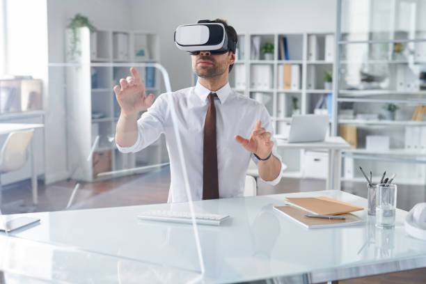 istock Elegant businessman in vr headset pointing at transparent computer screen 1161787933