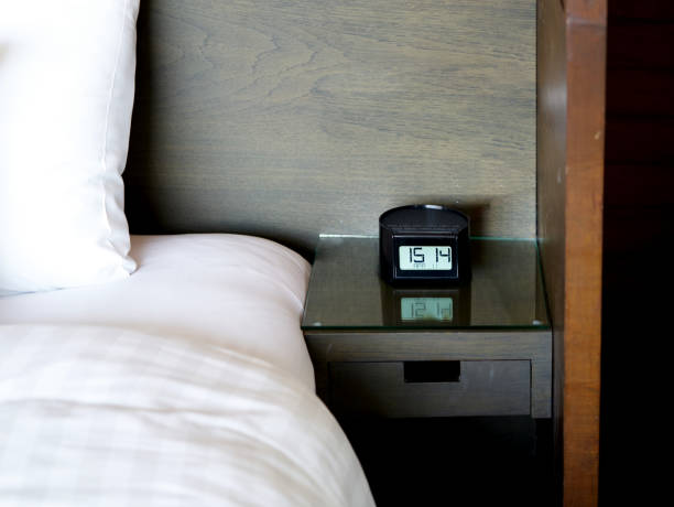 istock alarm clock on table bed at hotel in travel time concept 1161788946