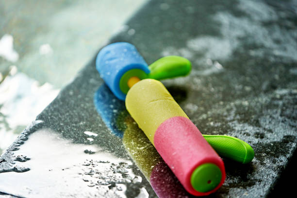 colorful Pump water gun on wet pool side bar