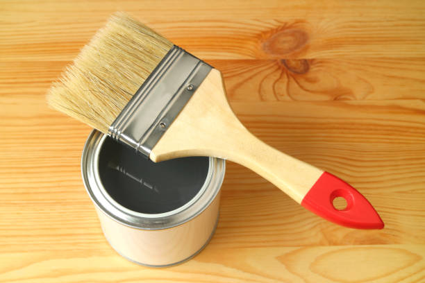 istock Paintbrush on an opened paint can isolated on wood plank background 1161789312