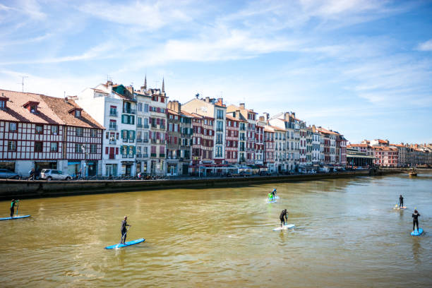 Bayonne, France - May 06, 2019: People paddleboarding on Nive river in Bayonne, France