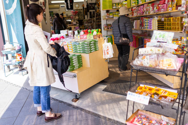 mulher que está pela loja e pela loja de presente do alimento, comprando lembranças da sobremesa doce do mochi na prefeitura de tochigi - 11193 - fotografias e filmes do acervo