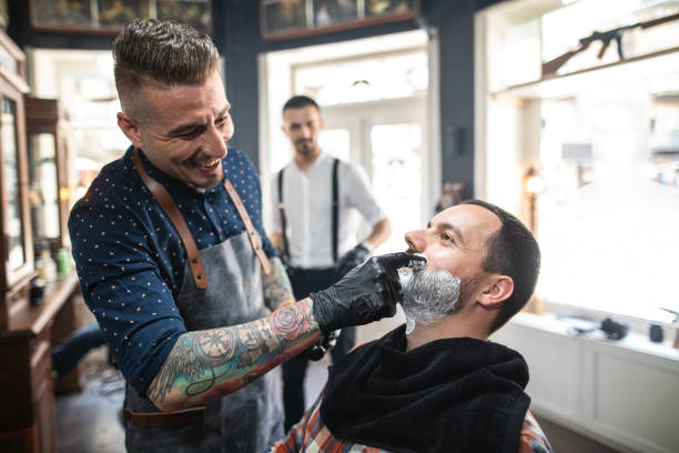 istock Cheerful barber serving a customer with a clean shave 1161791443