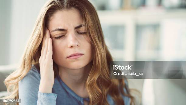 Young Woman With Headache In Home Interior Stock Photo - Download Image Now - Headache, Pain, One Woman Only