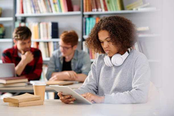 istock Serious girl sitting by desk at break and using touchpad 1161792644