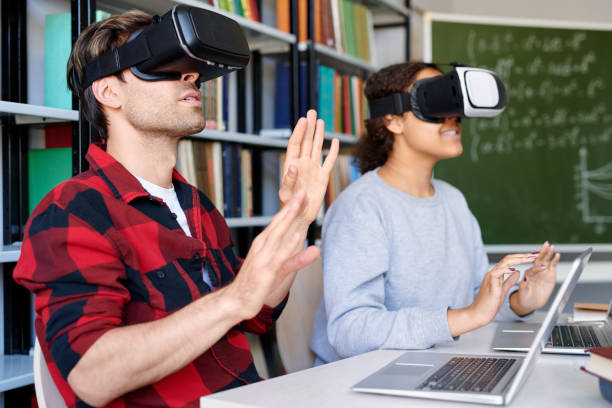istock Young man and his classmate in vr goggles touching virtual display 1161792663