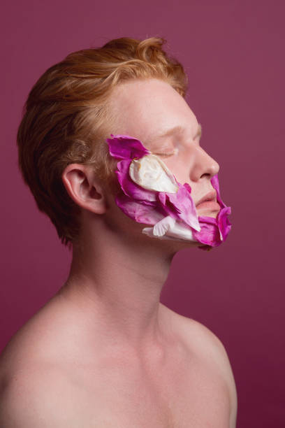 istock Young redhead man with flower petals on his face 1161799054