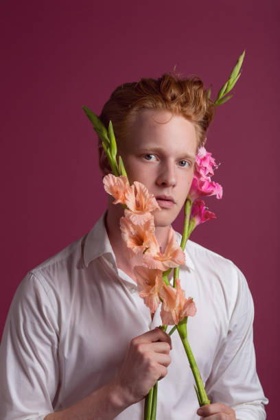 istock Young redhead man with flowers 1161799180
