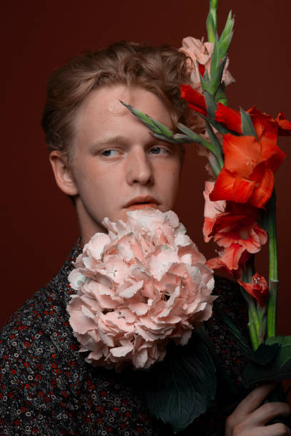 istock Young redhead man with flowers 1161799203