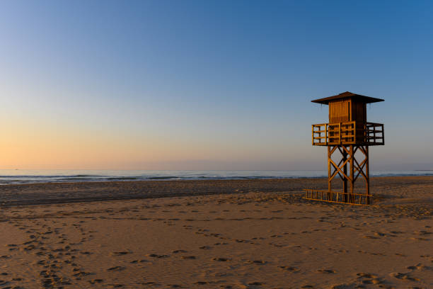 Stock picture of a lifeguard watchtower in early morning sun, at Cullera beach in Spain.