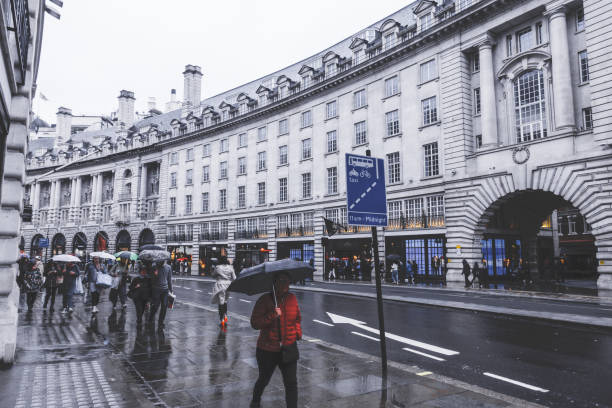 persone e traffico a piccadilly circus a londra. luogo famoso per lo shopping e i viaggi per turisti di gruppo e gente del posto nella stagione delle piogge. - london in the rain foto e immagini stock