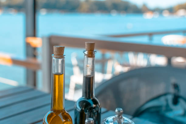 istock Olive oil and balsamic vinegar on a table and river background 1161802821