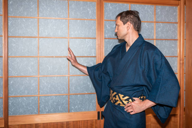 casa tradizionale giapponese o ryokan onsen con uomo in kimono apertura shoji porte di carta scorrevole con mano - obi sash foto e immagini stock