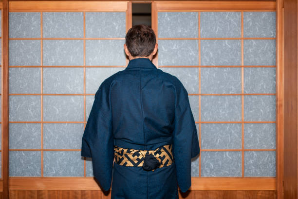 casa tradicional japonesa o ryokan onsen con la parte posterior del hombre en kimono apertura shoji puertas correderas de papel - obi sash fotografías e imágenes de stock