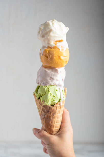 hand holding four scoops of ice cream in waffle cone hand holding four scoops of ice cream in waffle cone scoop shape stock pictures, royalty-free photos & images